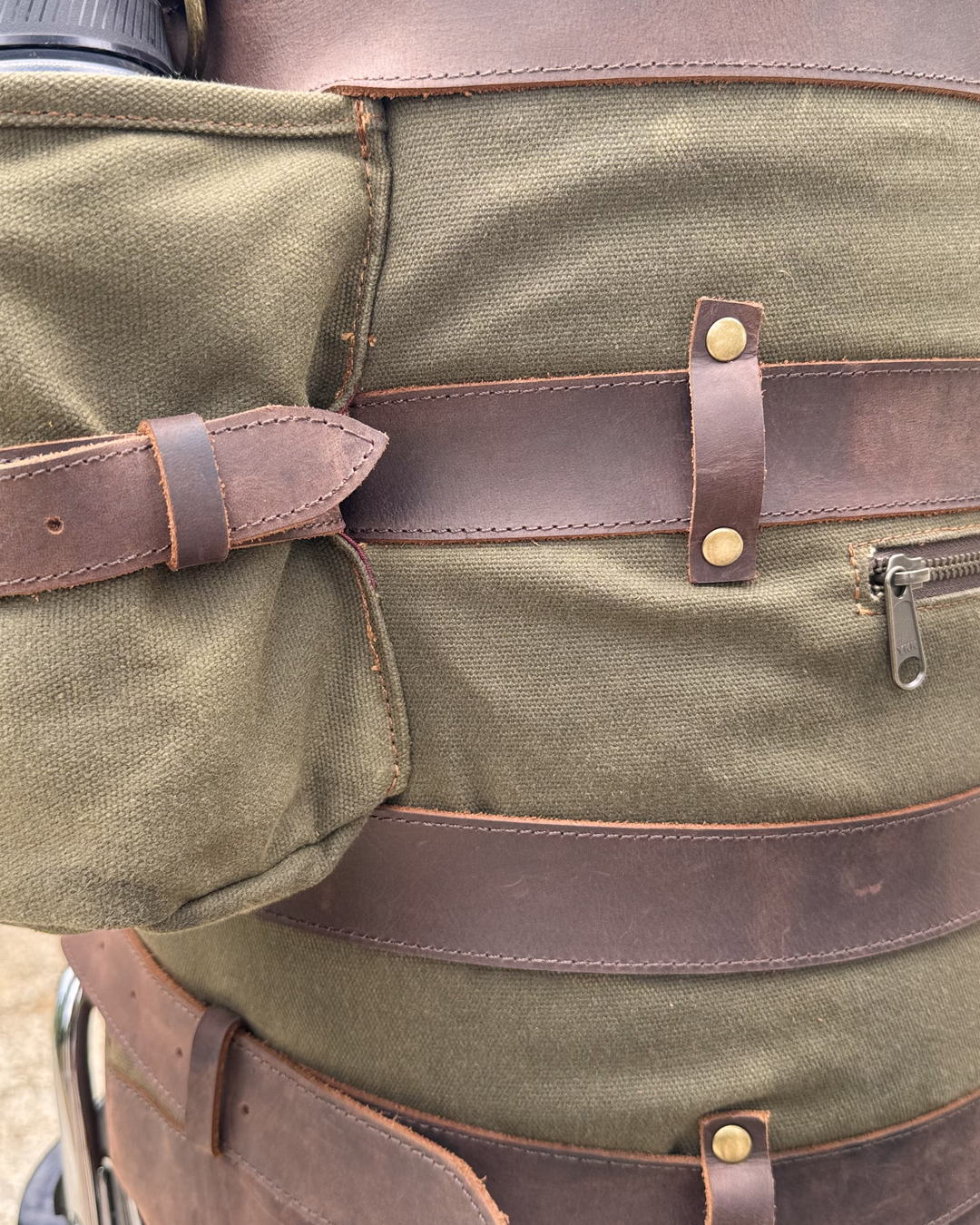 Side detail of the duffle bag, outside zipped pocket and full grain leather straps