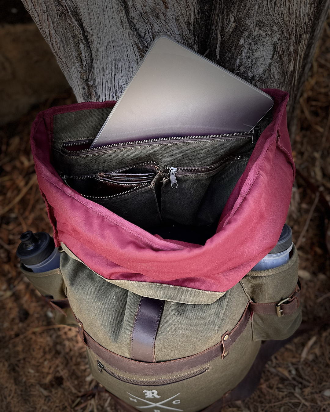 A laptop sliding into the padded compartment, inner lining and inside pockets visible