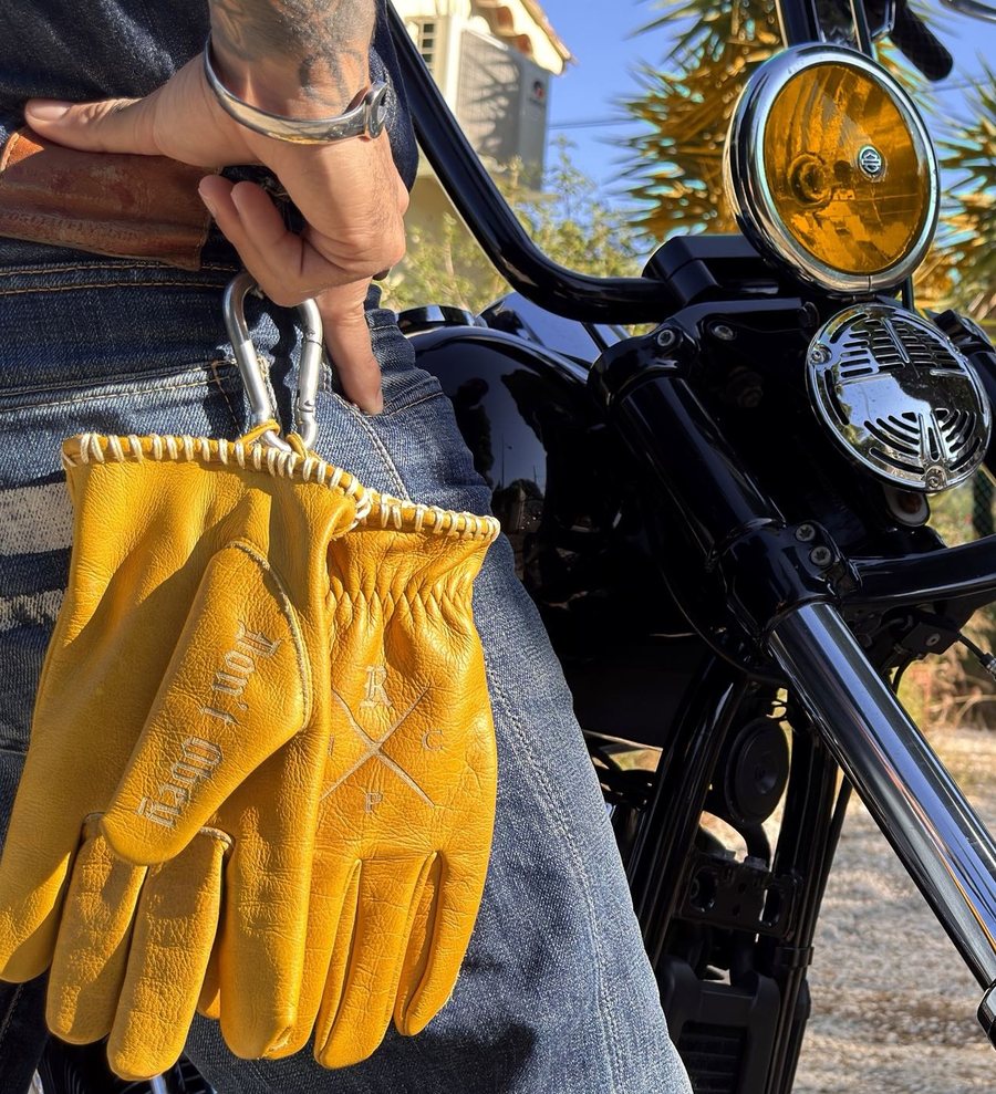 The Outlaw Gloves clipped to a jean pocket next to a chopper